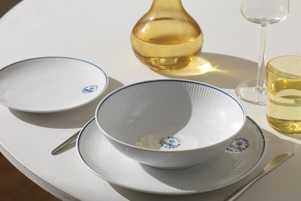 A white round table set for dinner or lunch with a Blueline dinner plate, a Blueline deep plate and a Blueline oval plate